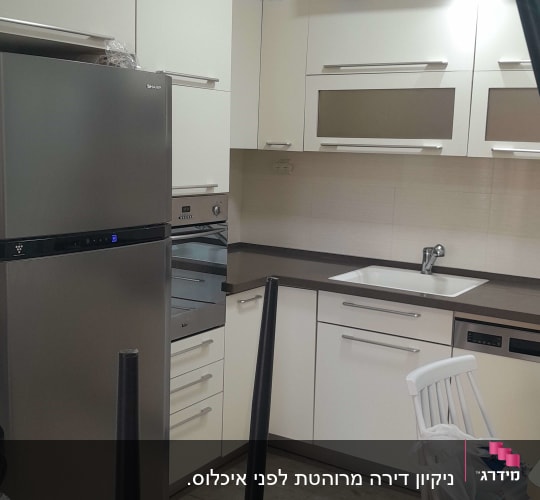 מטבח נקי עם מקרר, כיור וארונות לבנים